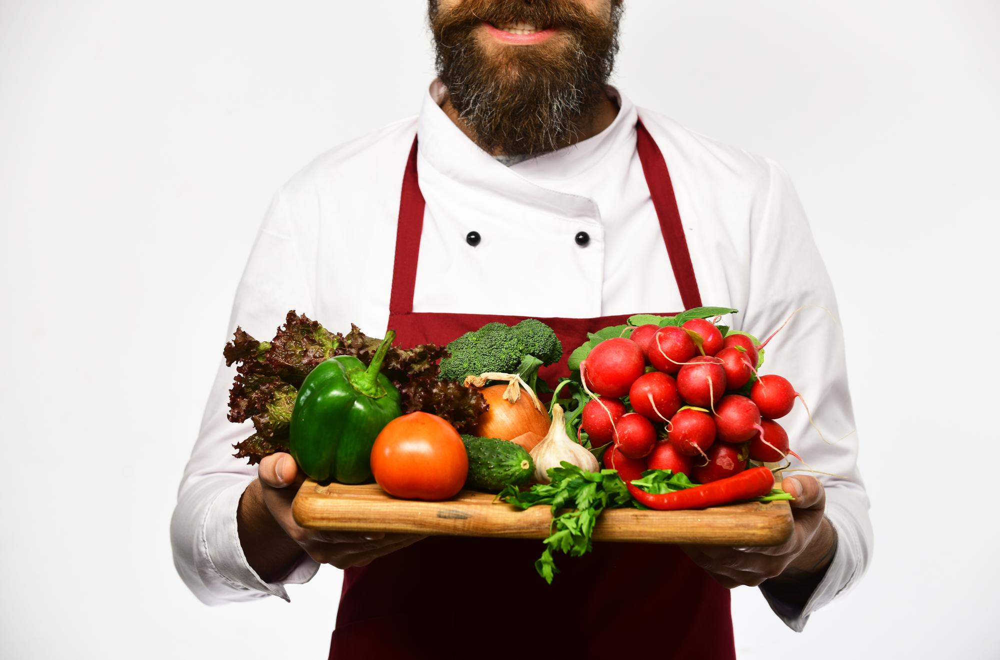 Artisan chef selecting fresh vegetables at market stall